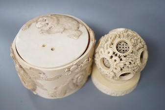 A late 19th century Chinese carved ivory concentric ball comprising seven reticulated spheres, with a small stand, and a Japanese carved ivory box (base missing), Meiji period, of cylindrical form, decorated with a black